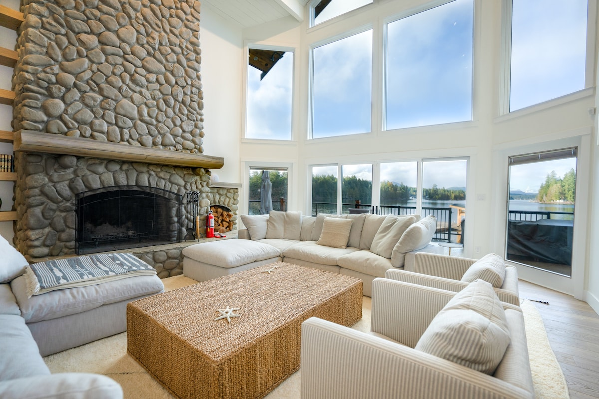 Living room with stone fireplace and panoramic lake views