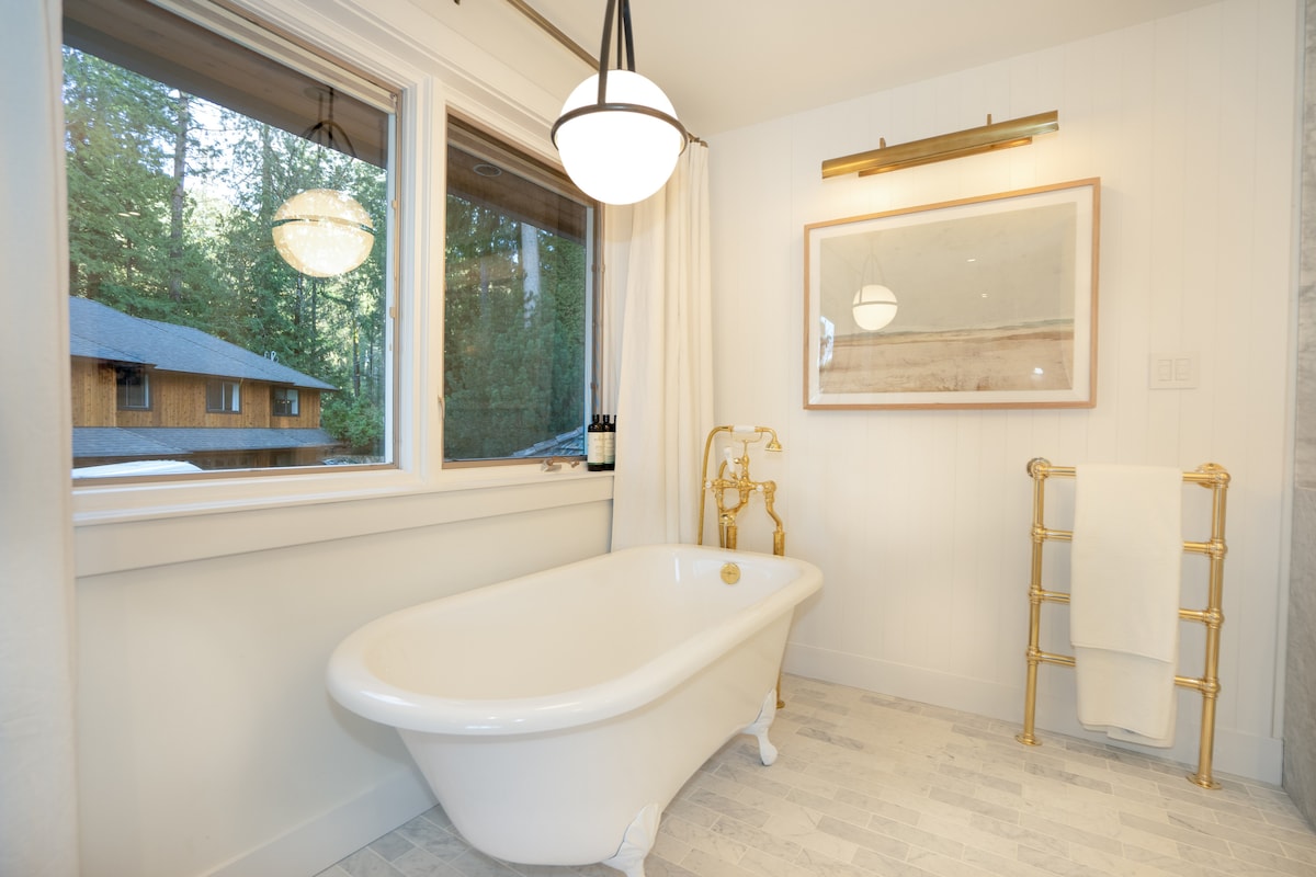 Clawfoot tub bathroom with brass towel warmer