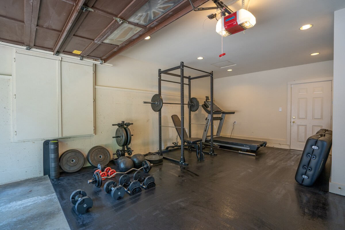 Home gym with squat rack, dumbbells and treadmill