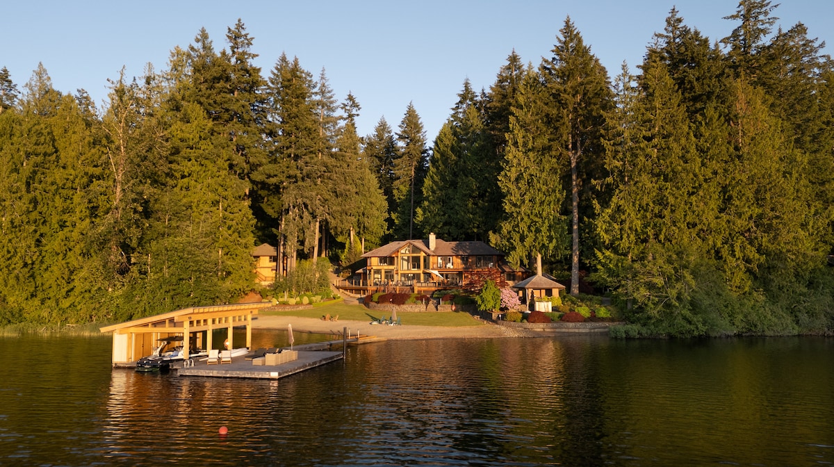 Estate at golden hour from the lake with dock and boathouse