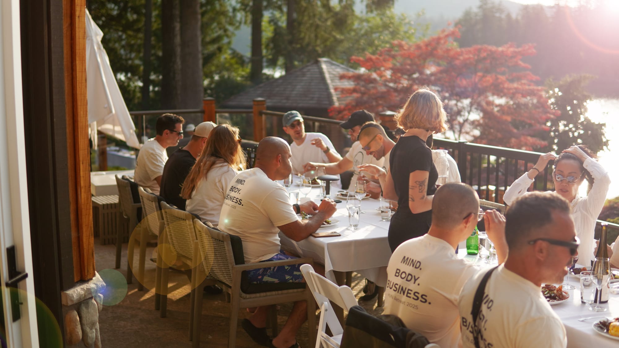 A long-table dinner laid out at sunset on the lakeside lawn