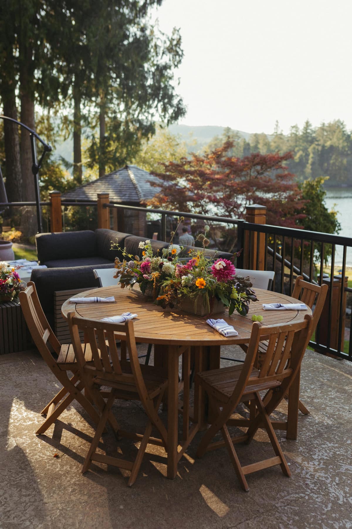 Wedding reception table set on the deck with lake views and string lights